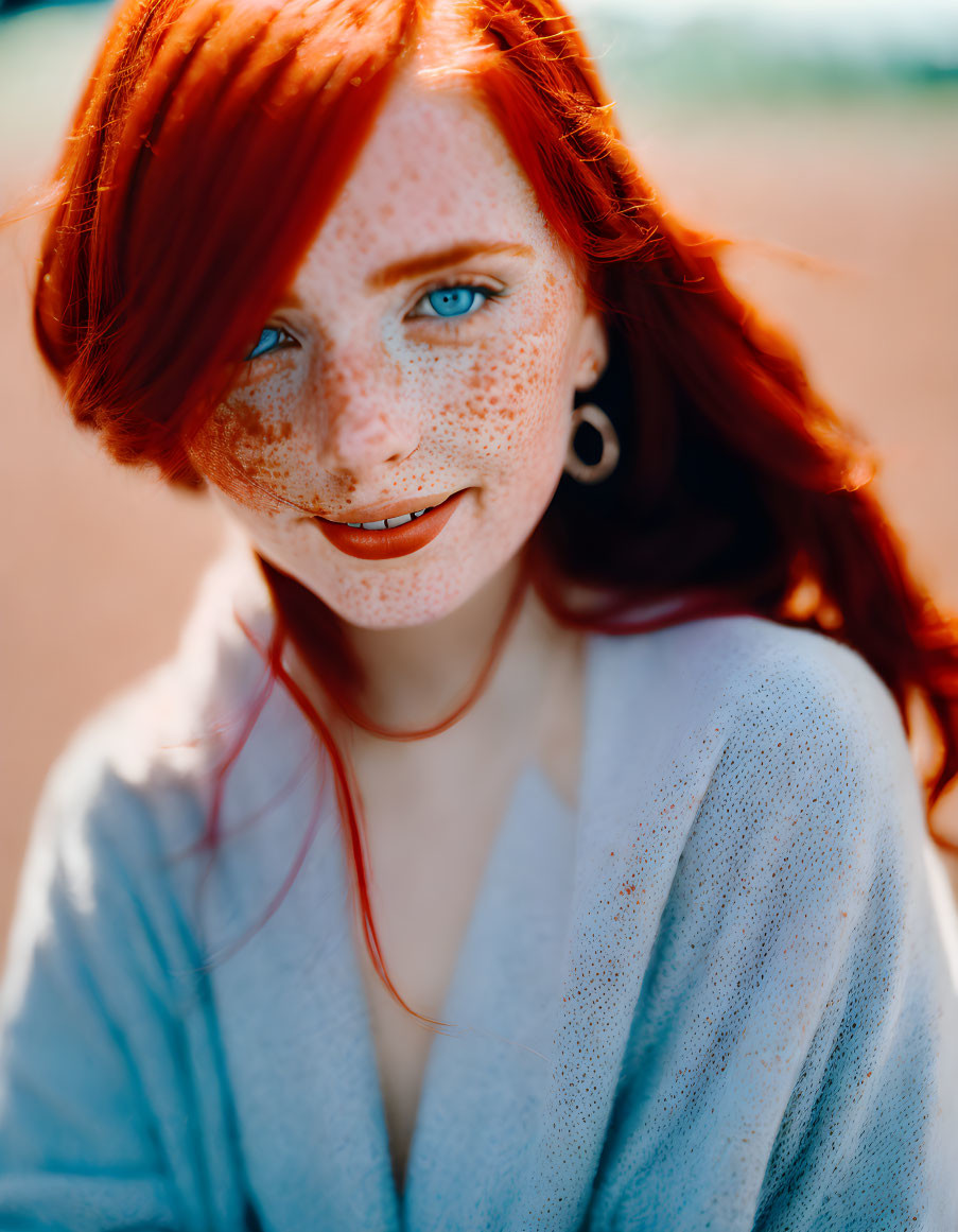 Red-haired woman with freckles and blue eyes in white outfit, blurred background