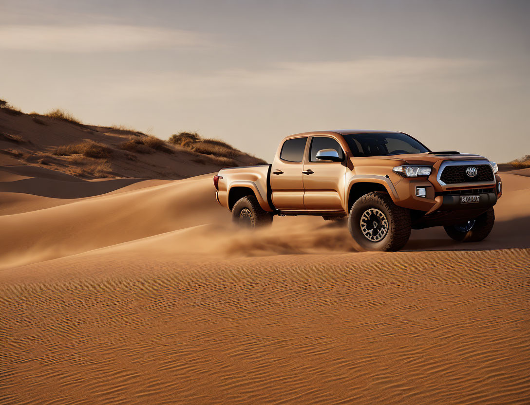 Pickup truck driving on sand dunes at sunset