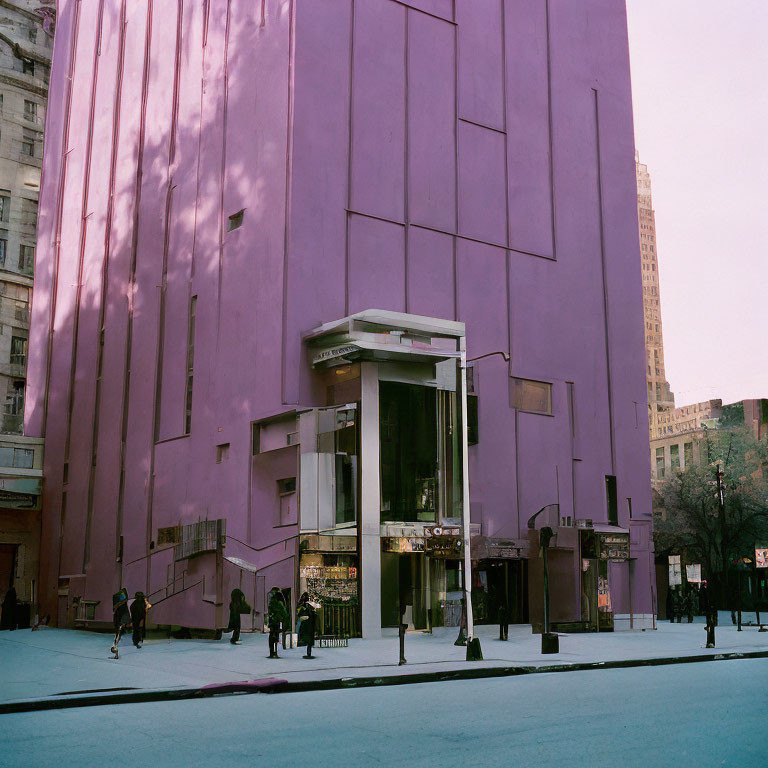 Urban scene with purple building and glass entrance pedestrians.