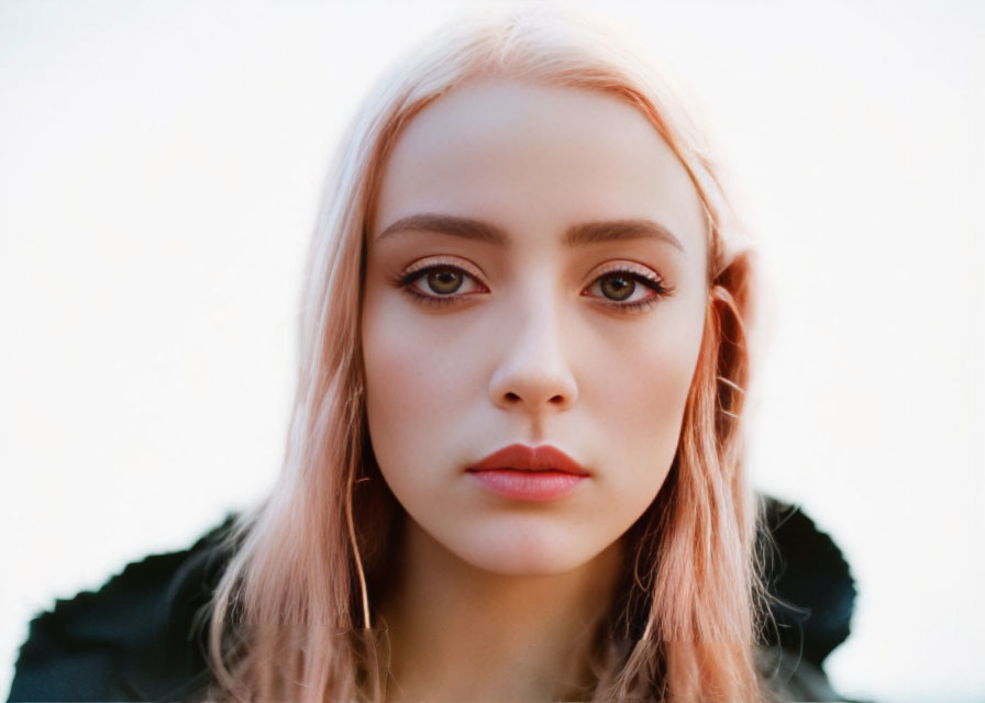 Portrait of person with pinkish hair, fair skin, and brown eyes.