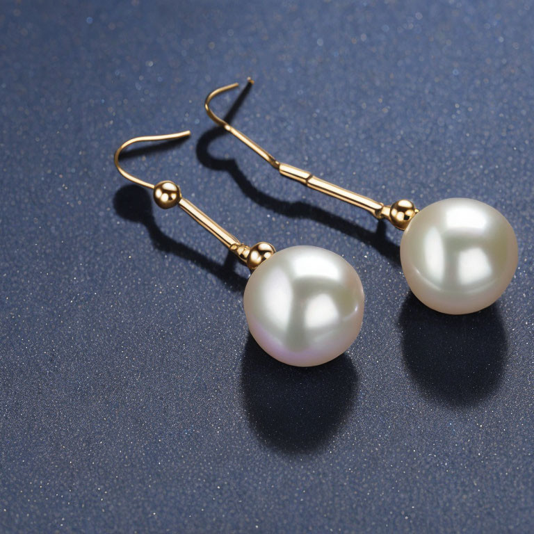 Pearl Drop Earrings with Gold Hooks on Dark Blue Surface