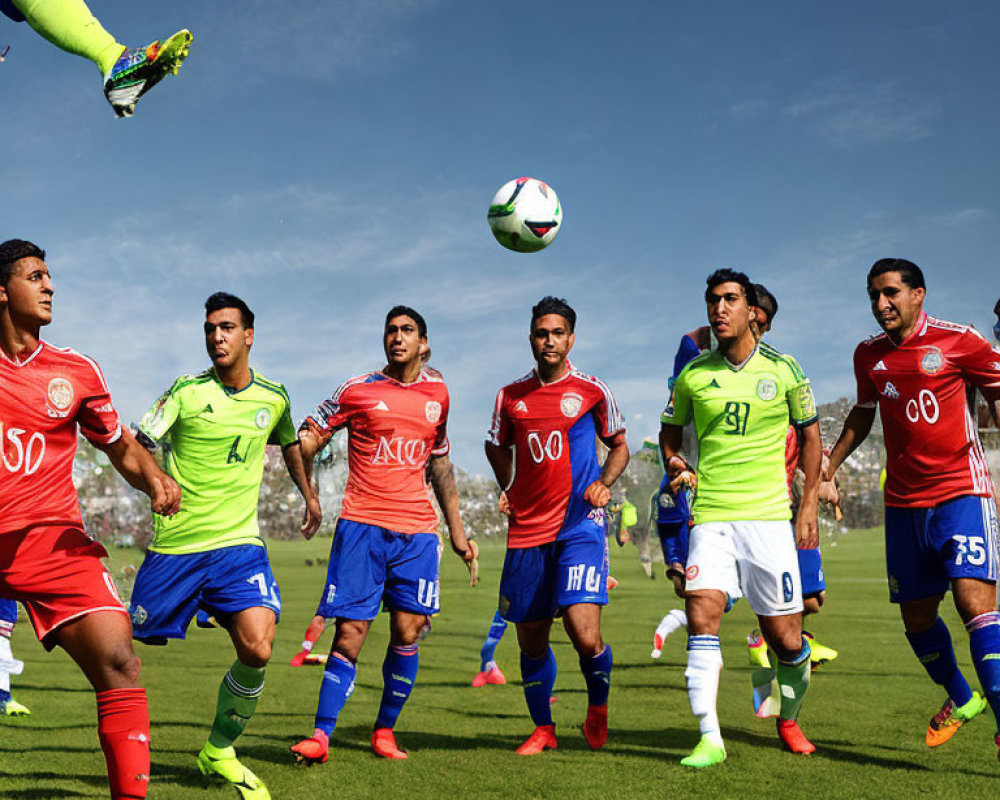 Professional soccer players in colorful kits playing during a sunny day match