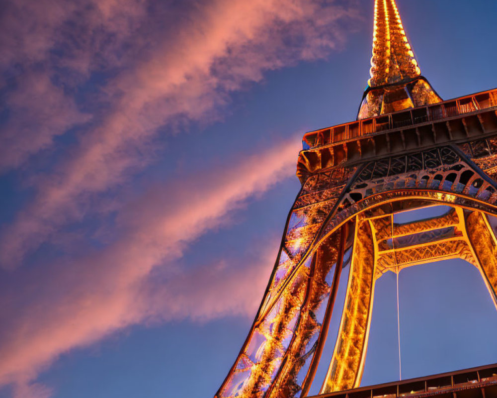 Iconic Eiffel Tower at twilight with vibrant sky and wispy clouds.