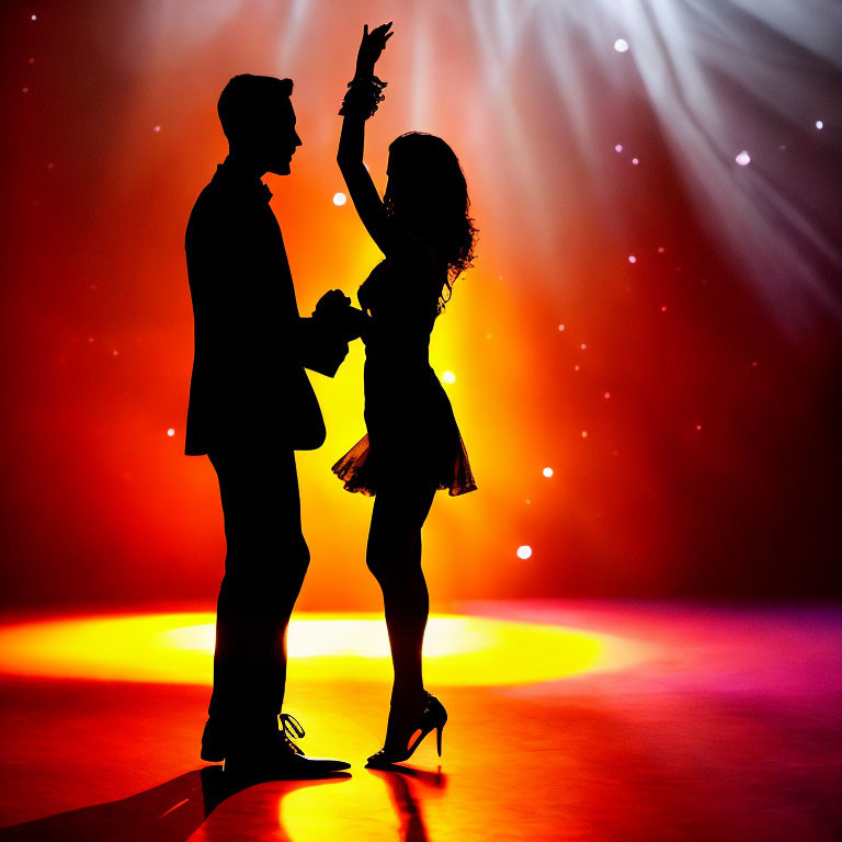 Silhouetted couple dancing on stage with colorful spotlight and haze