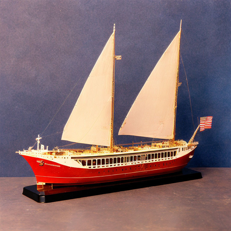 Detailed Classic Sailboat Model with Red Hull and American Flag on Stand