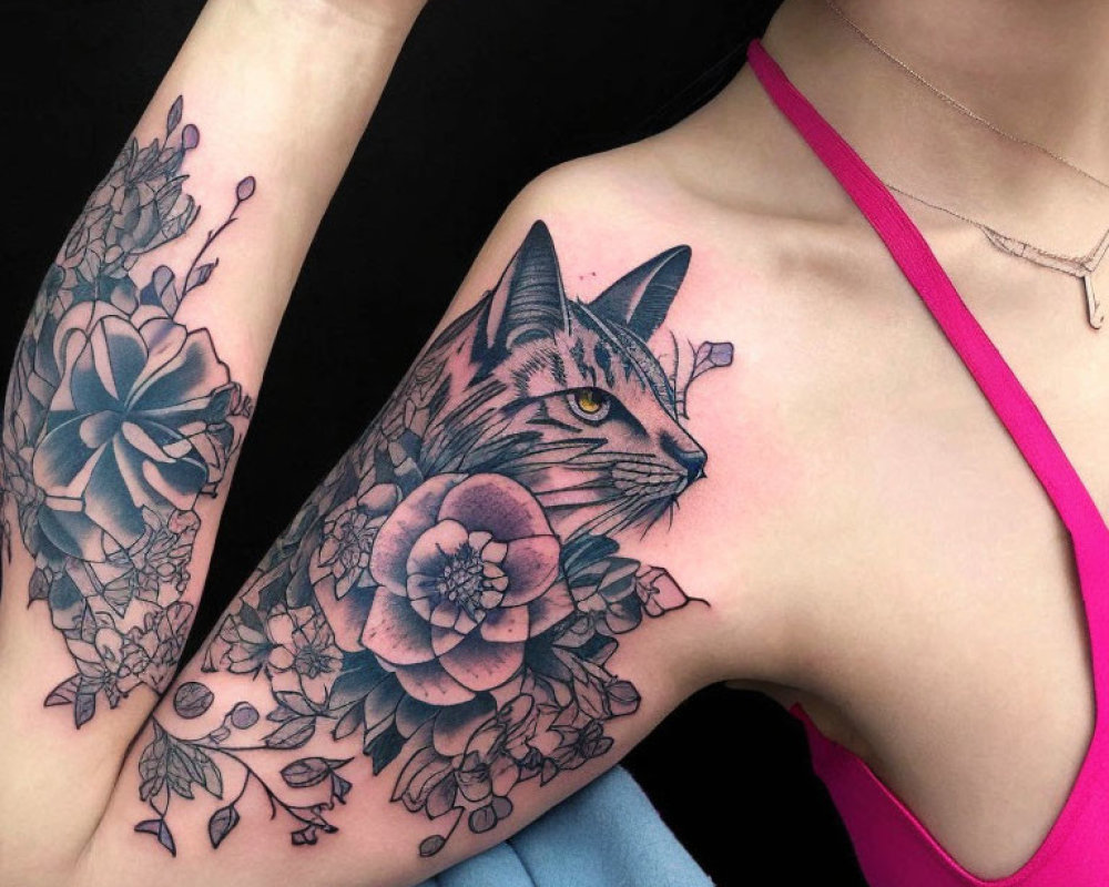 Cat Face Tattoo with Flowers and Leaves on Arm Against Black Background