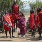 Traditional African dance performance in vibrant attire outdoors surrounded by trees