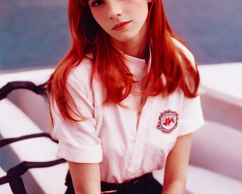 Woman with Red Hair and Badge in White Shirt and Black Trousers on Bench