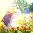 Woman with Purple Hair and White Hat Surrounded by Colorful Flowers in Sunlit Meadow