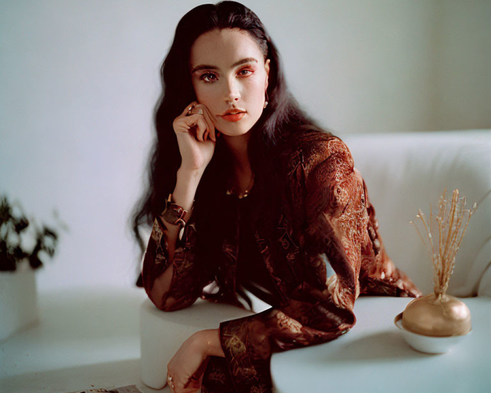 Dark-haired woman posing thoughtfully in soft-lit vintage interior.