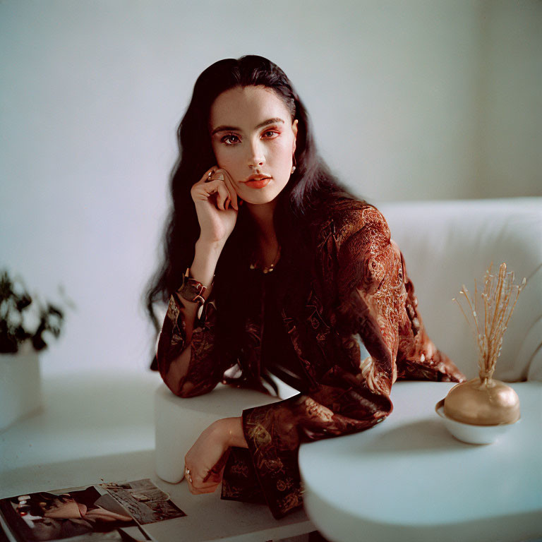 Dark-haired woman posing thoughtfully in soft-lit vintage interior.