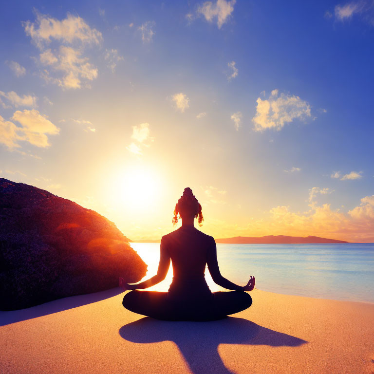 Silhouette of person meditating on serene beach at sunset