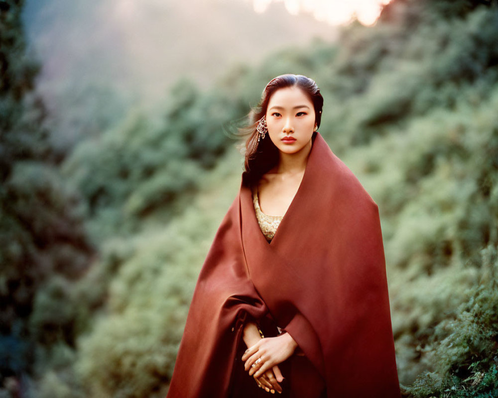 Poised woman in red cloak in lush forest setting