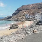 Sunny Beach with Colorful Umbrellas, Rocky Outcrops, Turquoise Sea