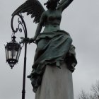 Female angelic figures statue with wings and dove in clouds