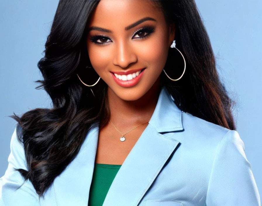 Woman with Long Dark Hair in Blue Blazer Smiling on Blue Background