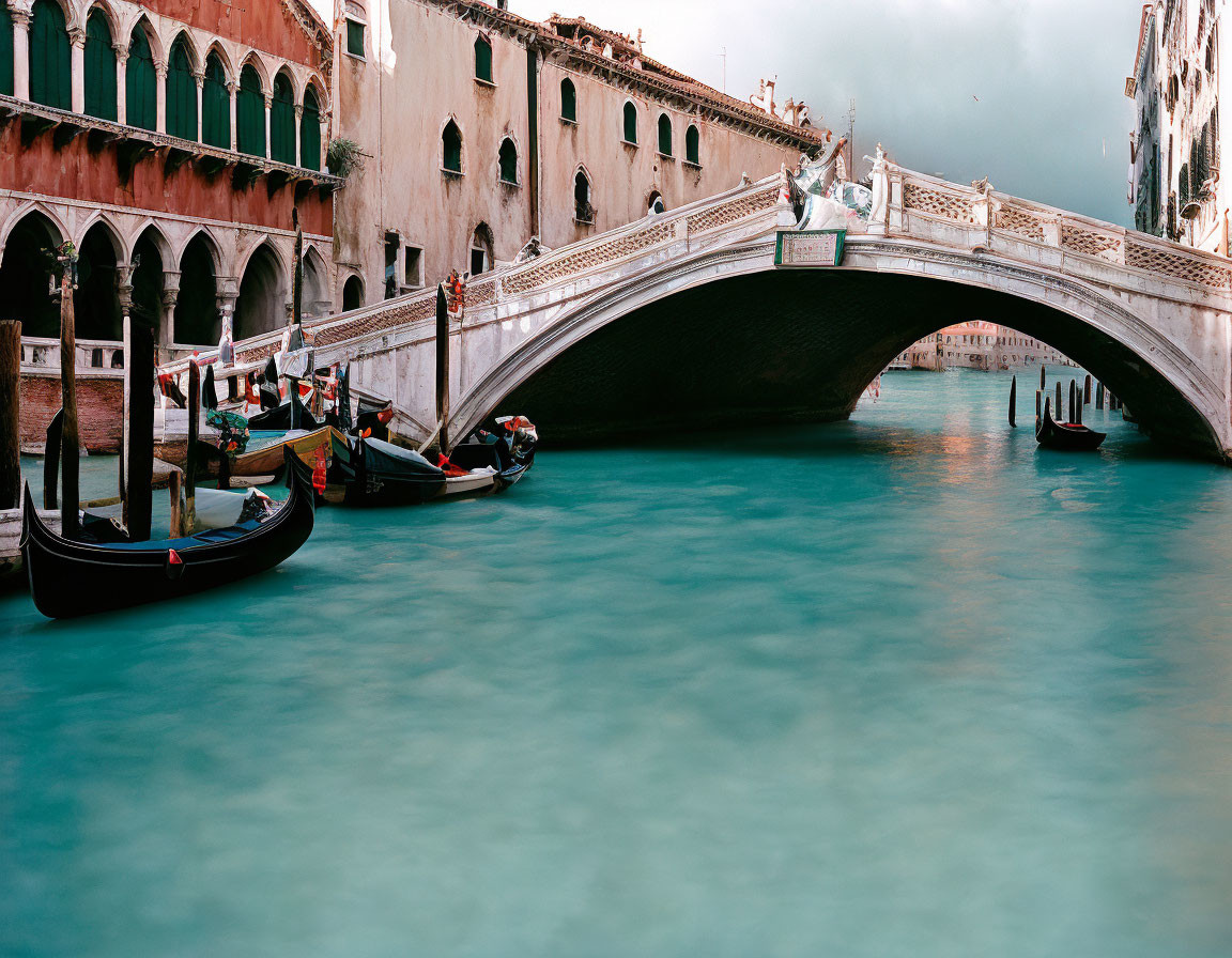 Stone bridge and gondolas on tranquil Venice canal