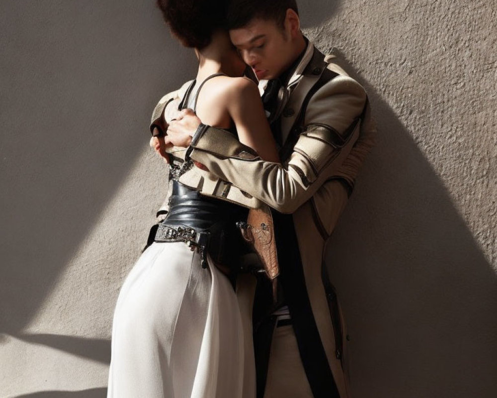 Affectionate embrace between two people against textured wall