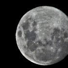 Detailed full moon with craters and maria against starry sky