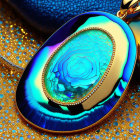 Iridescent object with concentric rings and gold detailing on a surface with golden droplets and blue