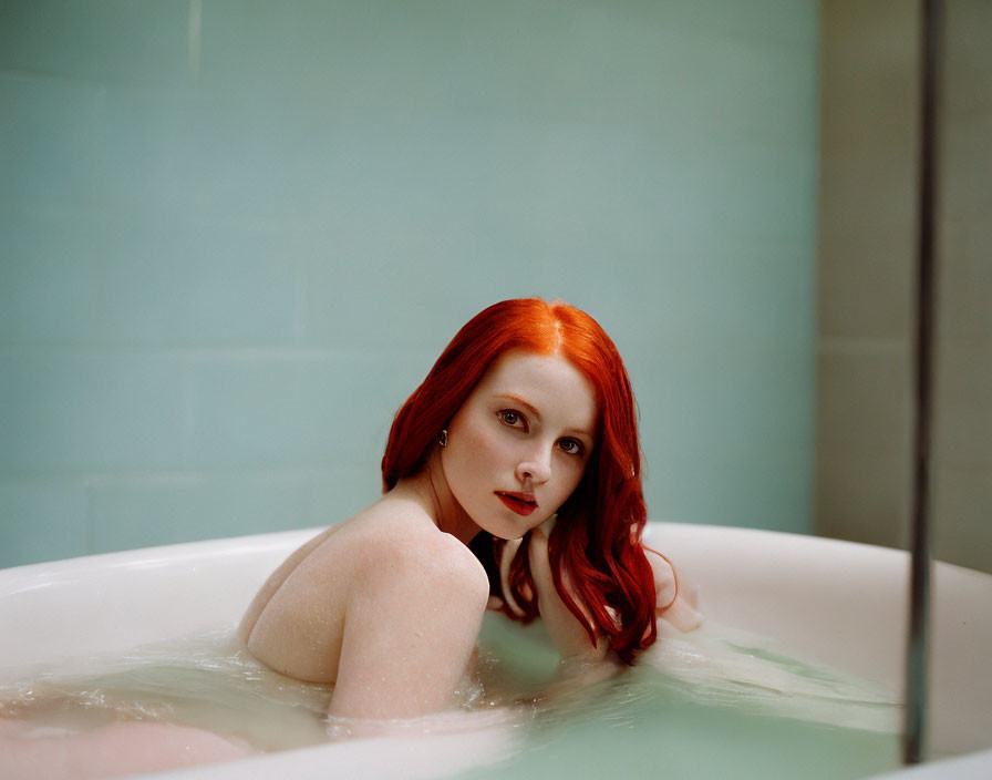 Red-haired woman in bathtub with serene expression