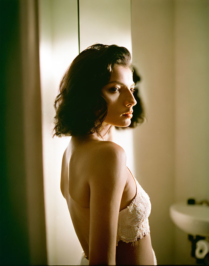 Profile of a woman in strapless top near window with side lighting