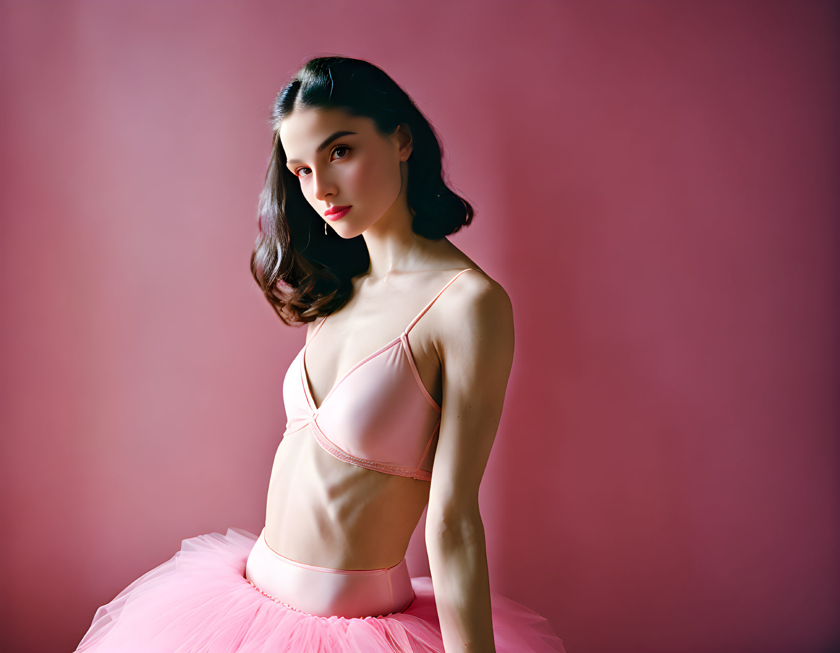 Ballet dancer in pink tutu costume on pink background