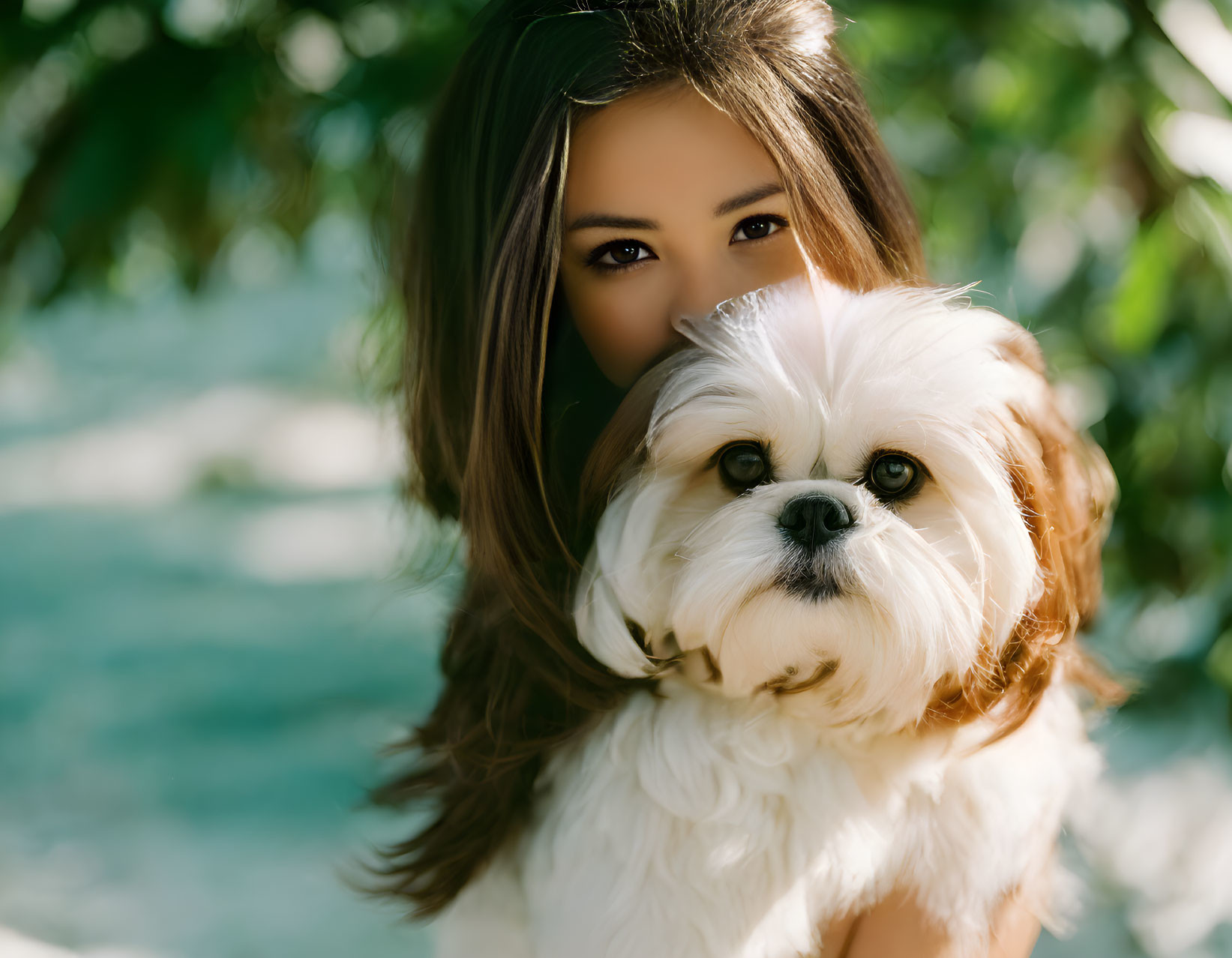 Woman Holding Fluffy White Dog in Green Foliage