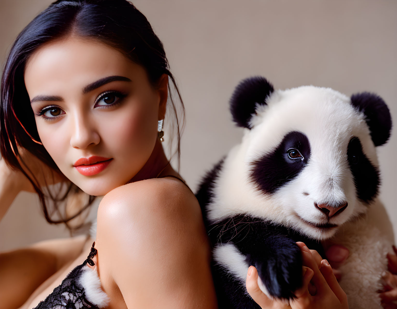 Woman Holding Panda Cub Against Neutral Background