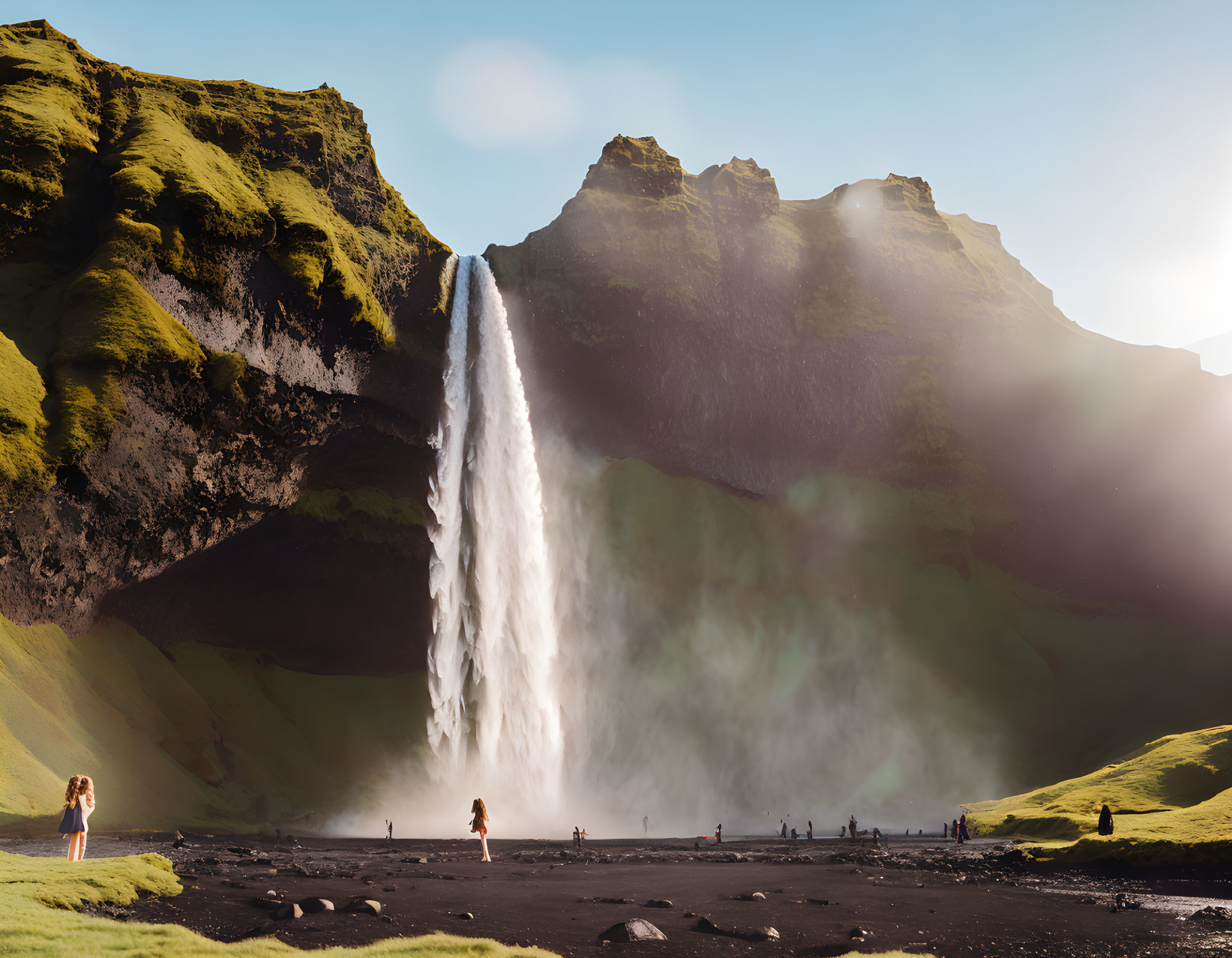 Verdant cliff face waterfall with mist and visitors in sunlight