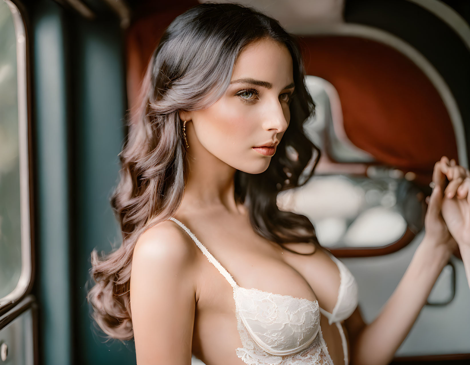 Dark-haired woman in white lace dress in vintage train compartment