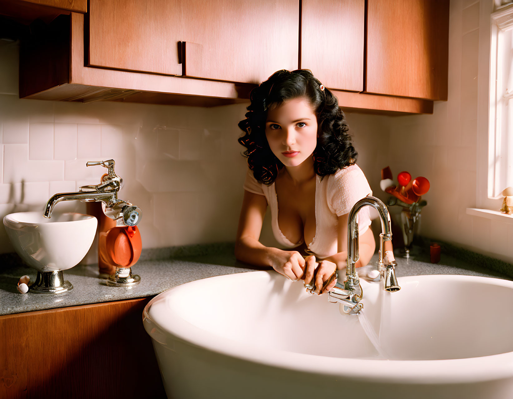 Dark-haired woman in pink dress by bathtub in vintage bathroom