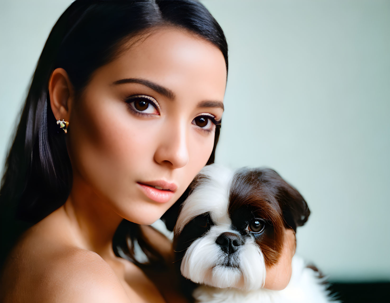 Dark-haired woman and small Shih Tzu dog pose together in a photo.