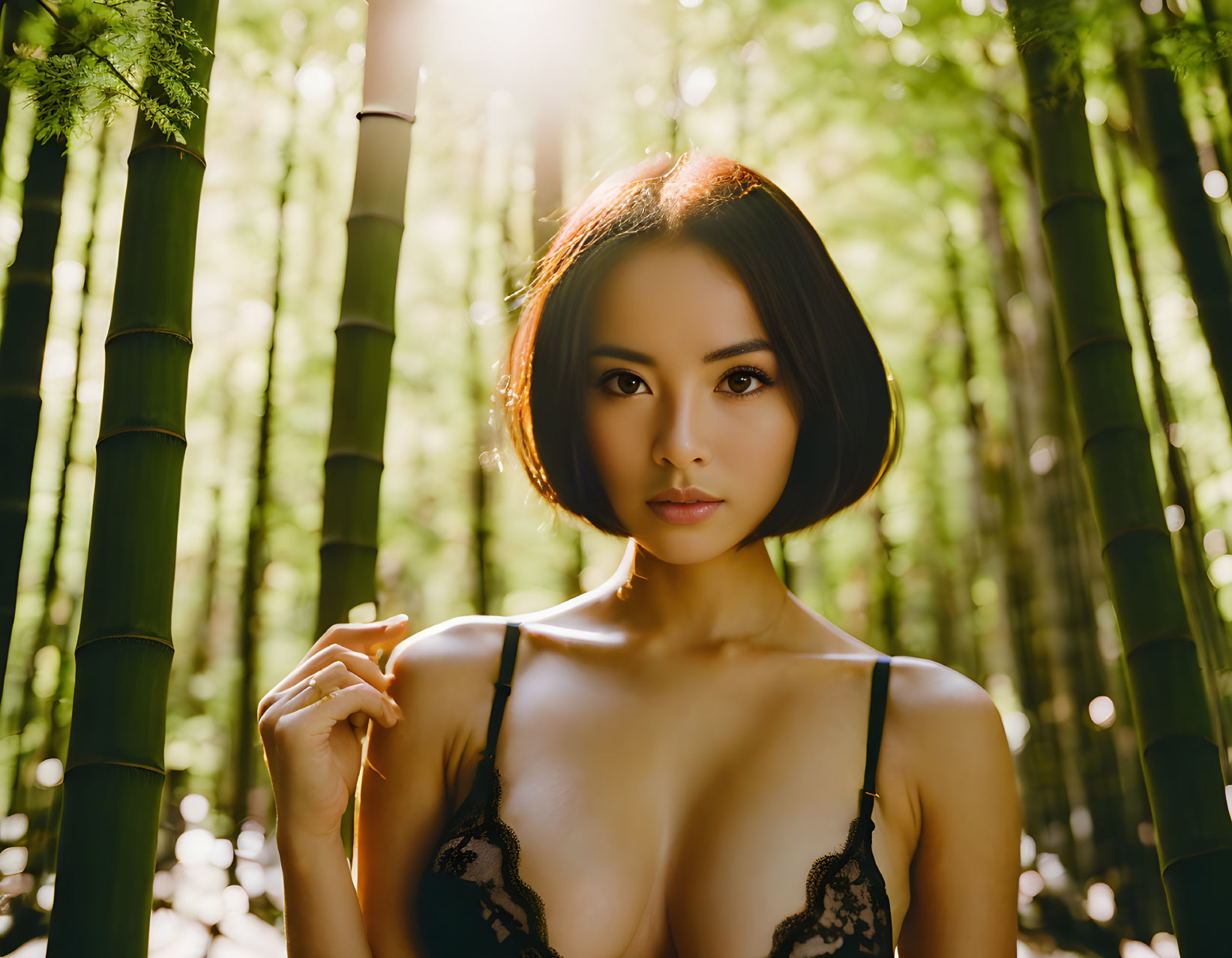 Woman posing in bamboo forest with sunlight filtering through leaves