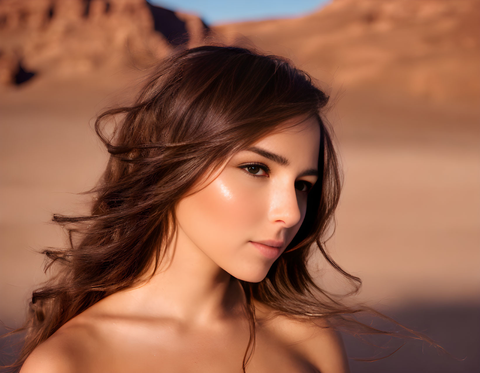 Woman with flowing hair and subtle makeup in desert setting