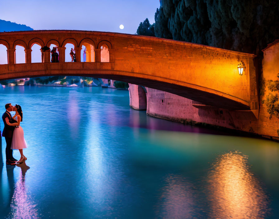 Romantic couple embraces near moonlit river and old arched bridge