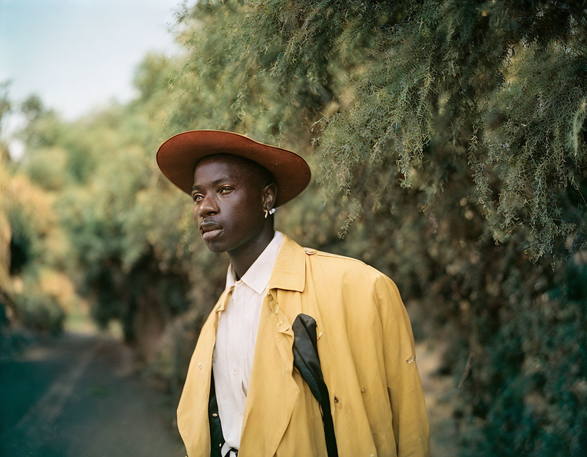 Man in Red Hat and Yellow Jacket Outdoors with Trees