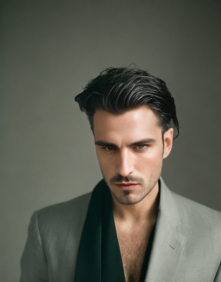 Dark-Haired Man in Gray Suit with Green Lapel Staring Intensely