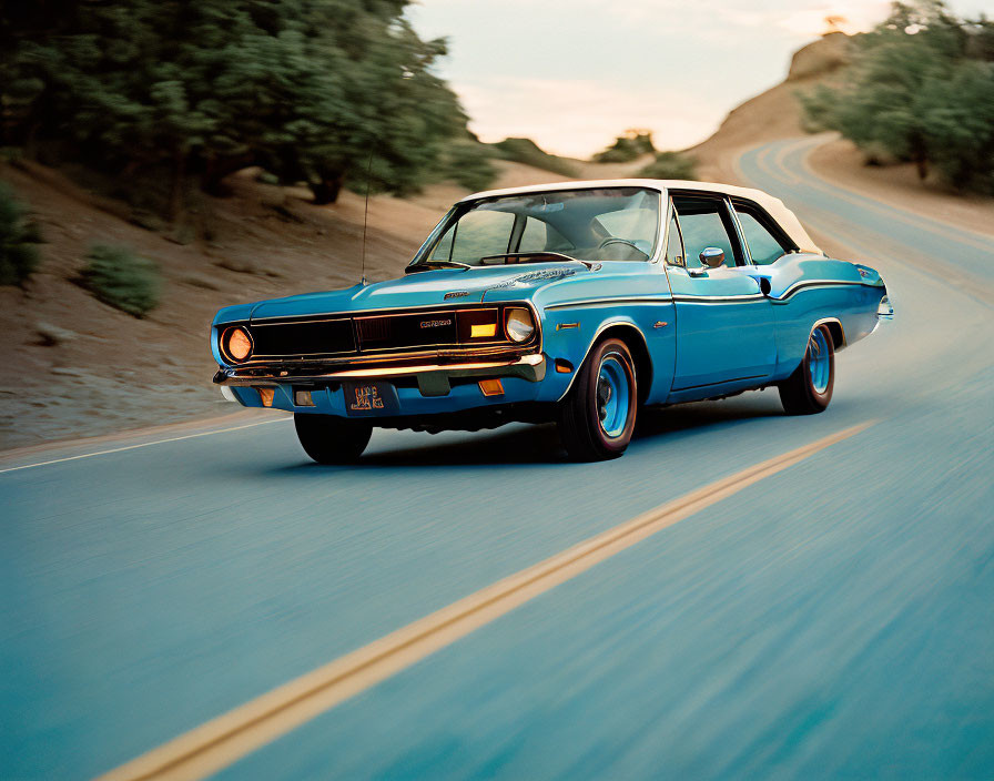 Vintage Blue Dodge Charger with Racing Stripes on Tree-Lined Road