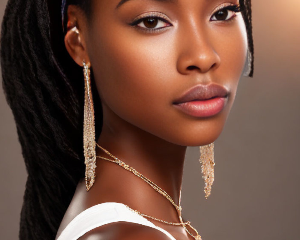 Portrait of woman with braided hair, gold earrings, delicate necklace, warm background