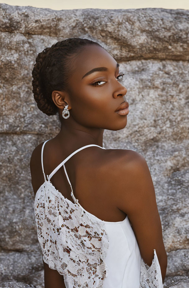 Woman in Braided Hair and Striking Makeup Poses in White Lace Dress