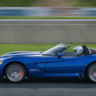 Futuristic blue sports car with sharp angles and neon highlights on racetrack