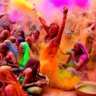 Traditional attired women dance in vibrant Holi festival colors