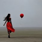 Woman in red dress and boots on misty shore with red balloon under crescent moon