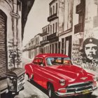 Vibrant street scene: vintage cars, Che Guevara mural, sunny day