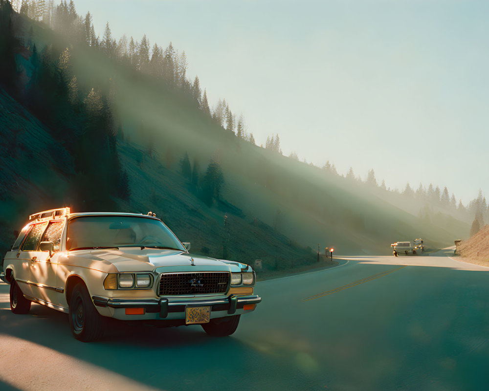 Vintage Car Driving on Sunlit Mountain Road with Fog and Pine Trees