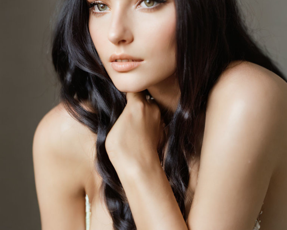 Pensive woman with long dark hair and green eyes in close-up portrait