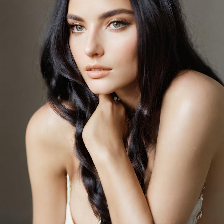 Pensive woman with long dark hair and green eyes in close-up portrait