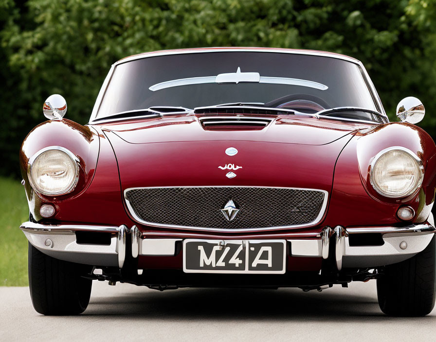 Red Sports Car with Chrome Bumpers and Round Headlights on Green Lawn