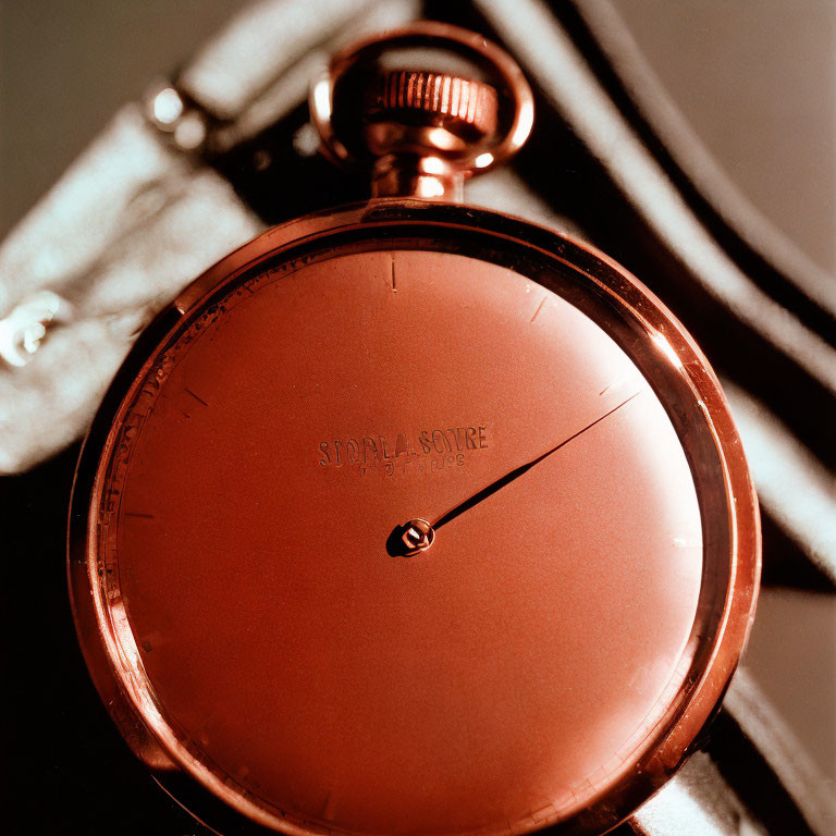 Vintage Red Pocket Watch with Black Hand and Textured Face in Soft Light